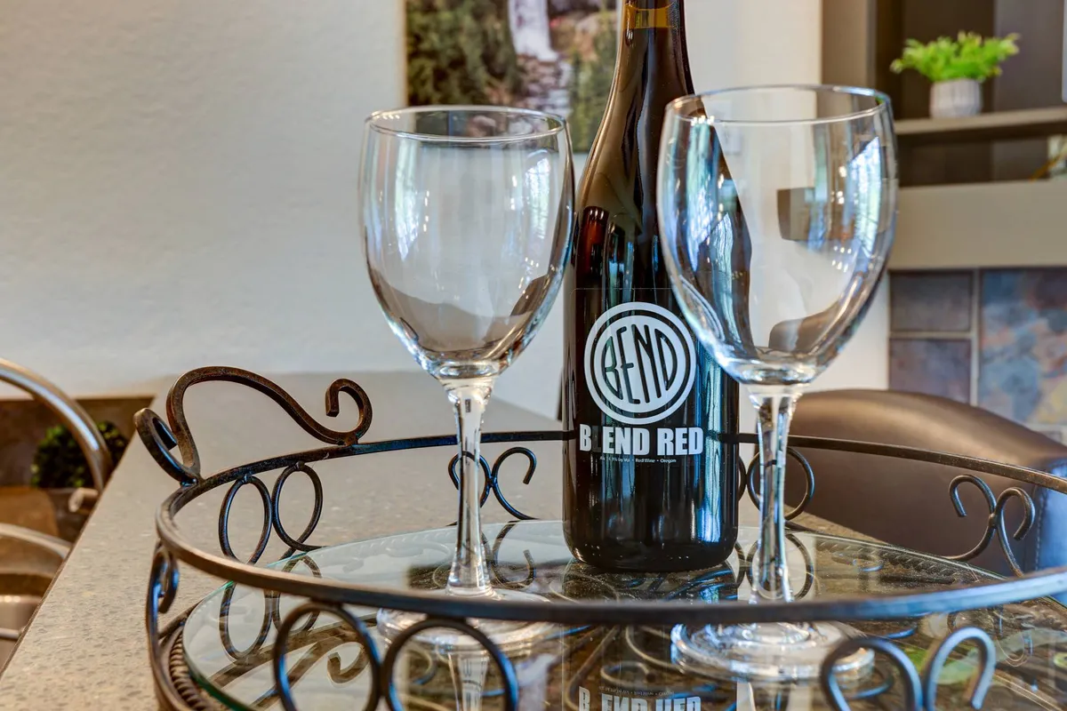 A decorative tray set with a wine bottle and glasses evokes the experience of relaxing after a day of tasting trails and brewery visits. The relaxed mood mirrors evenings spent unwinding with local beverages.